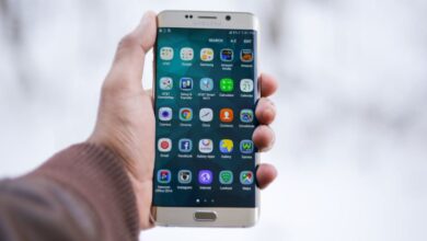 Apps - Close-up of a hand holding a Samsung smartphone displaying various app icons, emphasizing technology and connectivity.