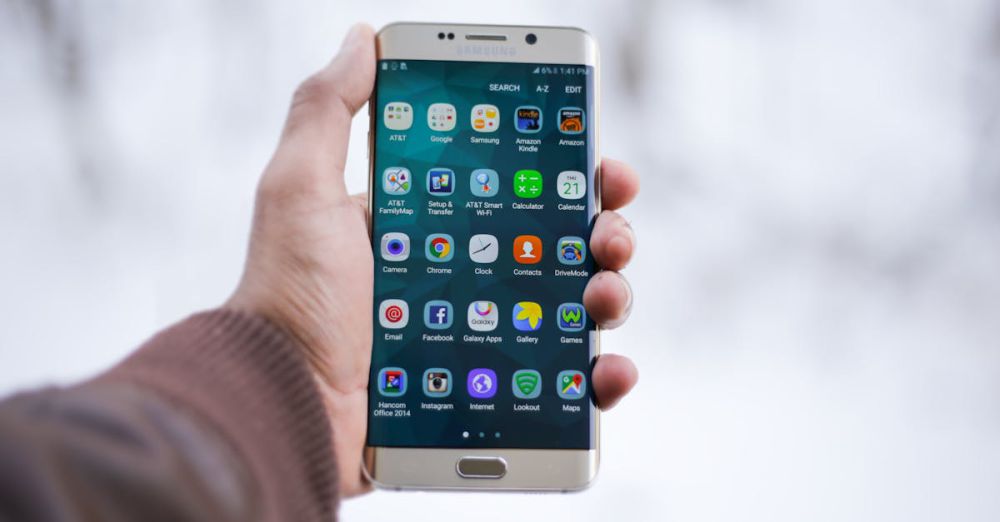 Apps - Close-up of a hand holding a Samsung smartphone displaying various app icons, emphasizing technology and connectivity.