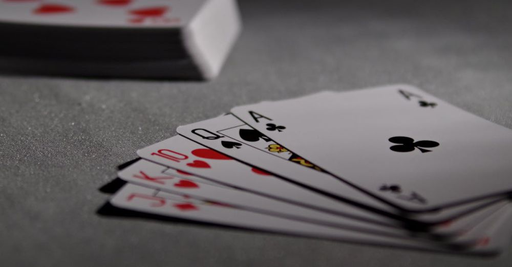 Cards - Detailed view of playing cards displaying a winning poker hand in a dimly lit scene.