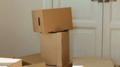 Clearance - Stack of cardboard boxes by a white wooden door, perfect representation of moving day readiness.