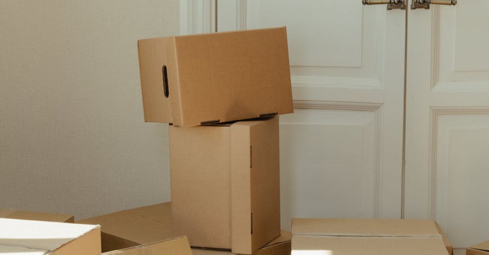 Clearance - Stack of cardboard boxes by a white wooden door, perfect representation of moving day readiness.