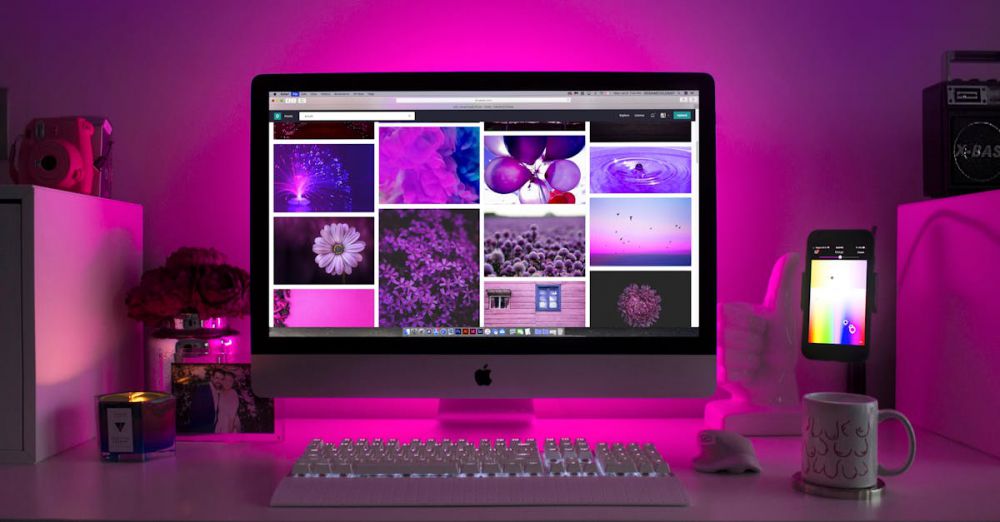 Websites - Modern desk setup with neon lighting and a desktop computer displaying colorful images.