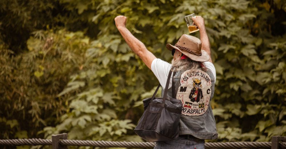 Leather Accessories - Man in cowboy hat celebrating outdoors, wearing custom jacket and holding beer.