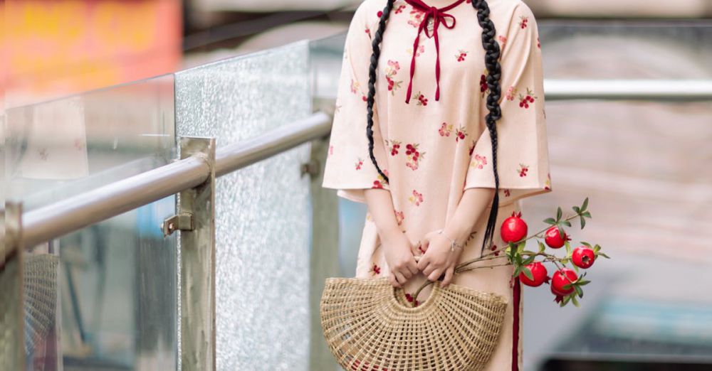 Hair Accessories - Young woman in floral attire with a woven bag and flowers standing outdoors on a sunny day.