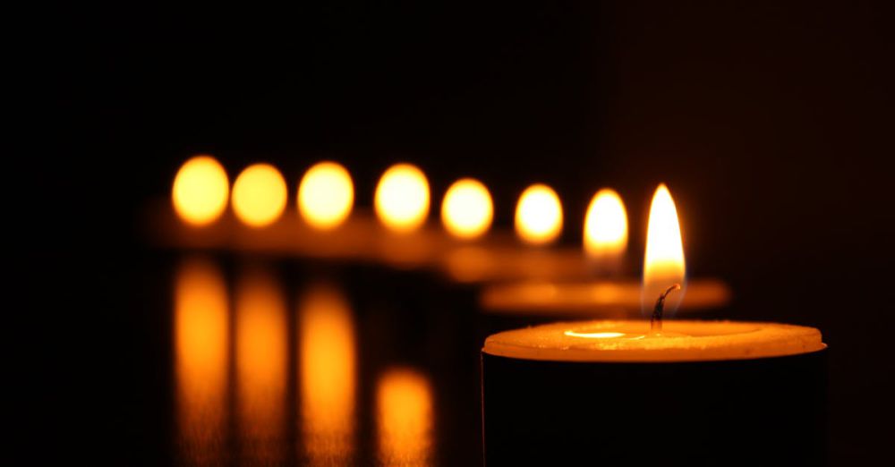 Candles - A close-up view of tealight candles reflecting a warm glow in the dark.