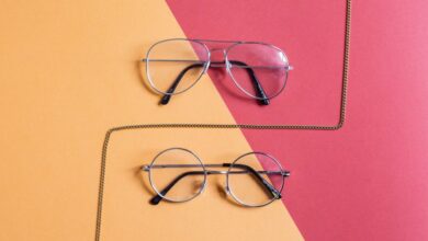 Accessories - Modern eyeglasses set against a red and yellow background with fashion chain.