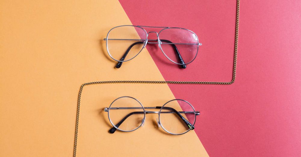 Accessories - Modern eyeglasses set against a red and yellow background with fashion chain.