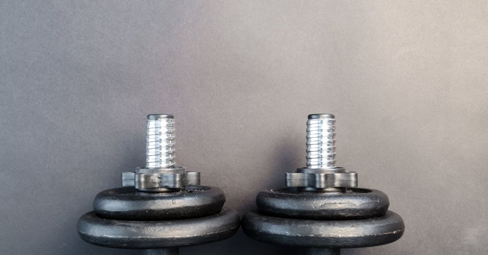 Dumbbell Set - Close-up of two iron dumbbells on a gray background, perfect for strength training images.