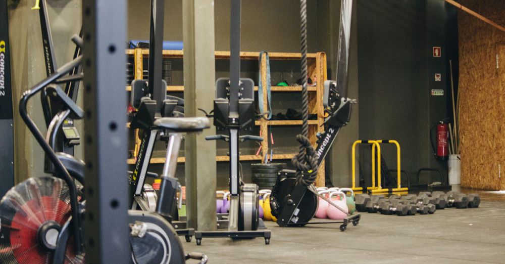 Rowing Machines - An indoor gym with various exercise equipment and weights ready for workout.