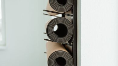 Yoga Props - Close-up of neatly rolled yoga mats stored vertically on a rack in a studio.