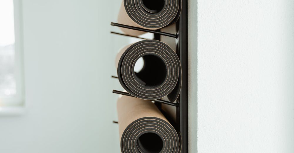 Yoga Props - Close-up of neatly rolled yoga mats stored vertically on a rack in a studio.