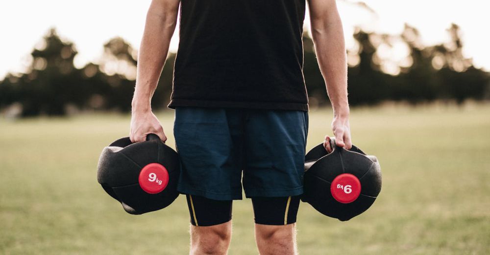 Medicine Balls - Man exercising outdoors with medicine balls in a park setting, promoting fitness and strength.