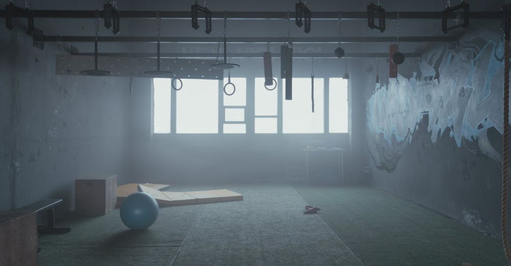 Pull-Up Bars - Empty industrial-style gym room with functional fitness equipment and natural lighting.