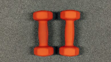 Strength Tools - A close-up image of orange dumbbells on a textured gray surface, ideal for fitness themes.