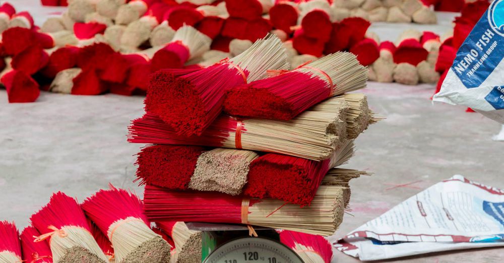 Equipment Bundles - Bundles of red incense sticks drying on the ground, showcasing traditional craftsmanship.