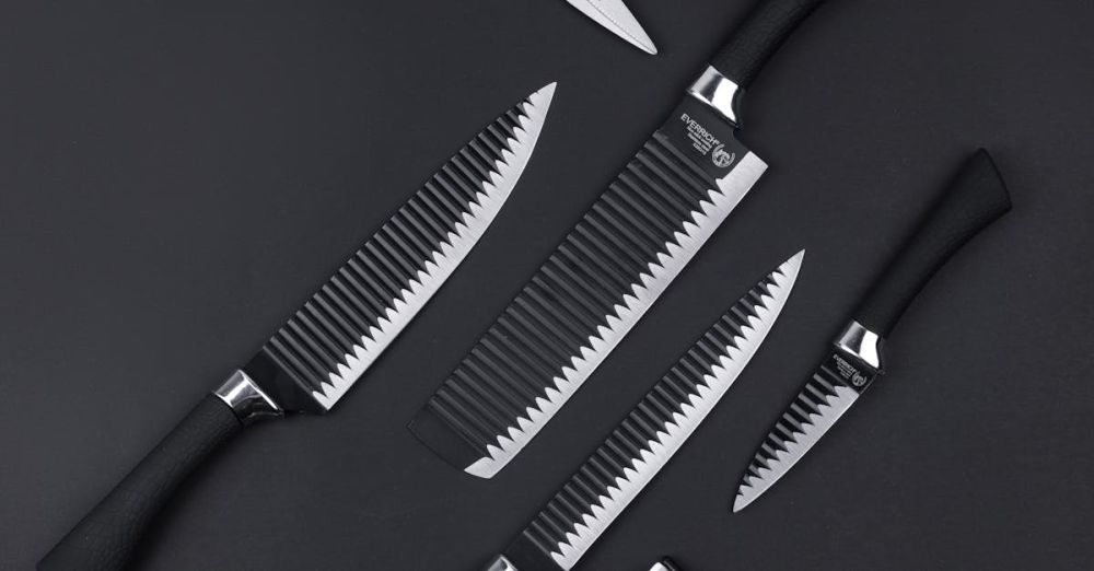 Chef’s Knives - Top view of various kitchen utensils including knives scissors and vegetable peeler on black background