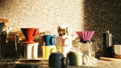 Coffee Makers - Sunlit kitchen counter with various coffee makers and mugs.