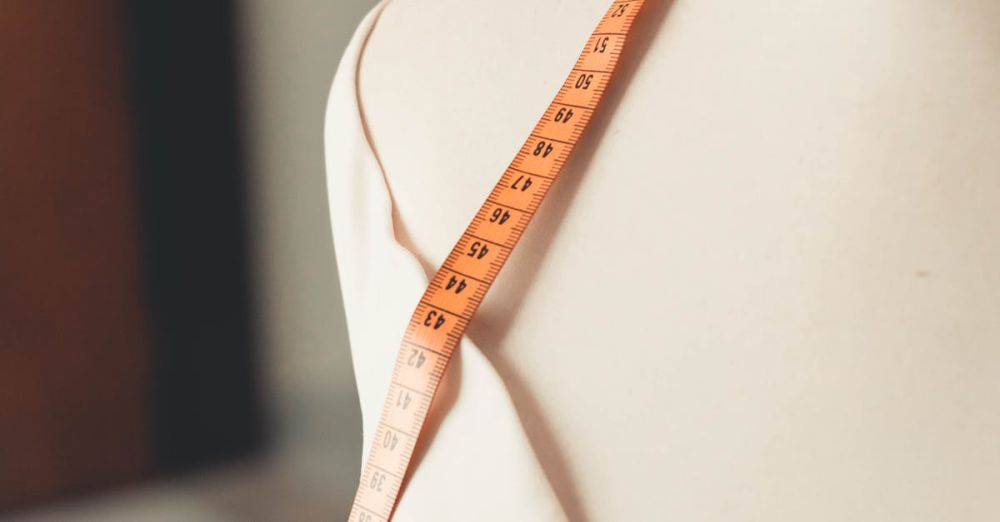 Measuring Tools - A close-up of a mannequin with a measuring tape draped over, depicting fashion design and tailoring.