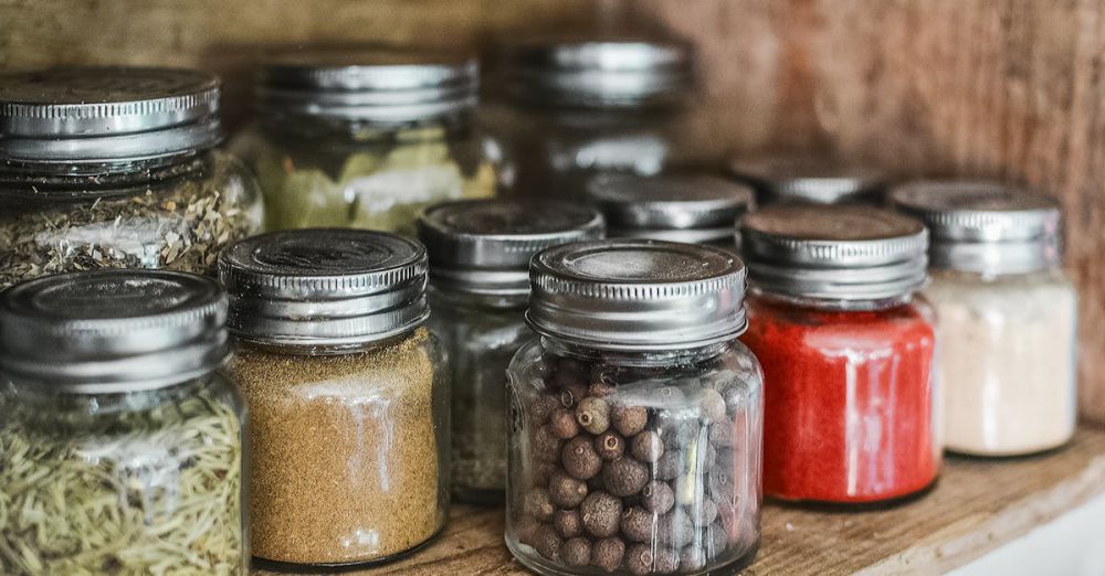 Food Storage - Close-up of assorted spice jars with various herbs on a kitchen shelf, showcasing colorful culinary ingredients.