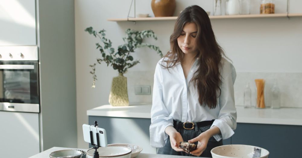 Mixing Bowls - Woman baking in a stylish kitchen, recording a vlog on her phone.