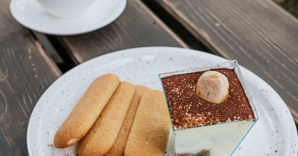 Ice Cream Makers - Tiramisu dessert with ladyfingers and coffee on a rustic wooden table outdoors.