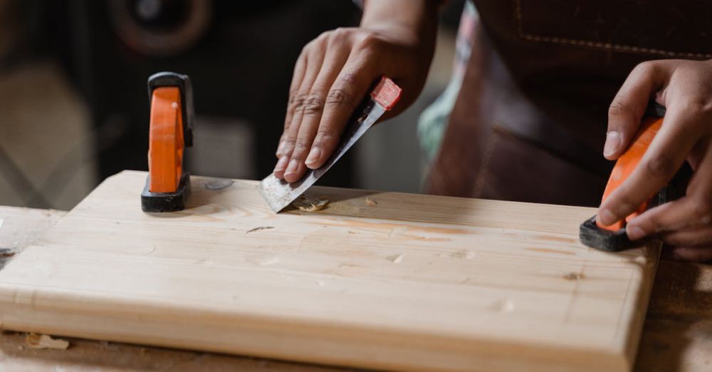 Tools - Hands crafting a wooden plank with clamps and tools. A focus on precision woodworking.