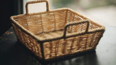 Basket - A close-up of a handmade wicker basket with handles, showcasing intricate weaving indoors.