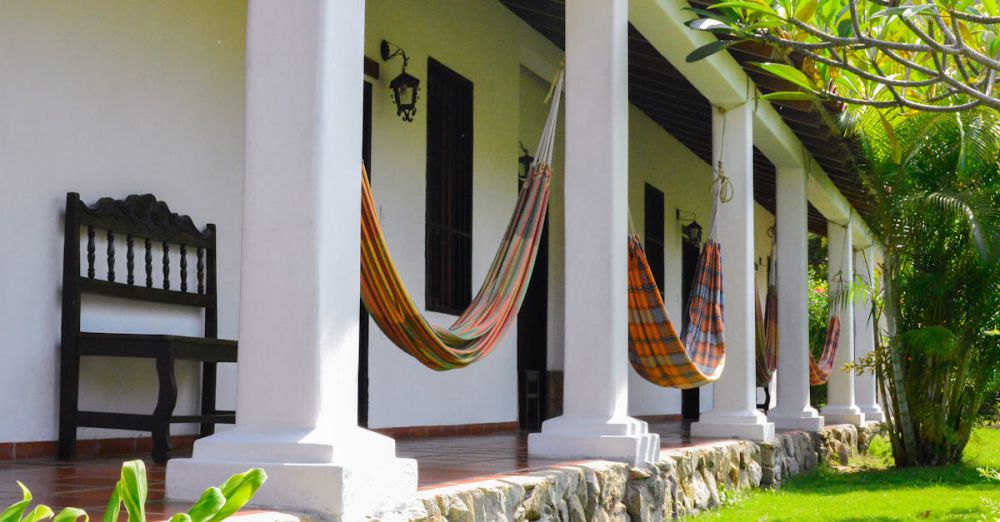 Hammocks - Front view of a traditional colonial house with hammocks and vibrant greenery, Falcón, Venezuela.