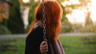 Swing Sets - A woman with red hair on a swing in a serene autumn park setting.