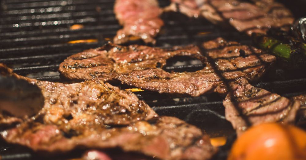 BBQ Grills - Deliciously grilled steaks over a barbecue with tomatoes. Perfect for outdoor cooking enthusiasts.