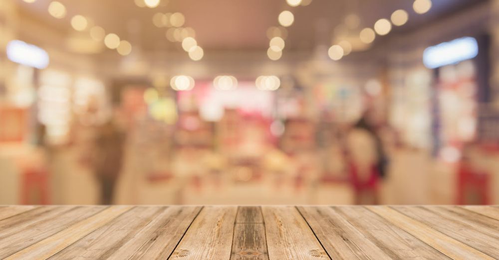 Tables - Empty wooden table with blurred shopping mall background and bokeh lights.