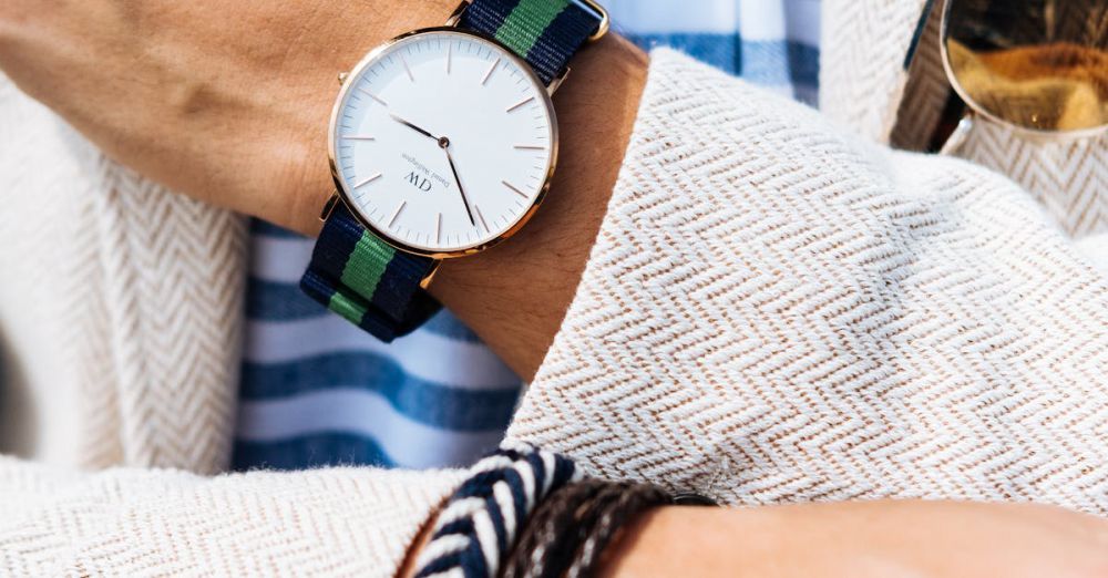 Accessories - Close-up of a fashionable man's wrist showcasing a striped watch and bracelets.