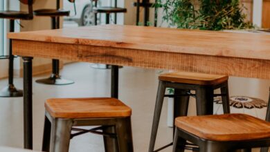 Tables - Contemporary restaurant interior featuring wooden tables and stools with natural light.