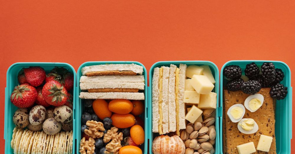 Snack Boxes - Top view of diverse snack boxes arranged neatly on an orange backdrop, ideal for meal prep inspiration.