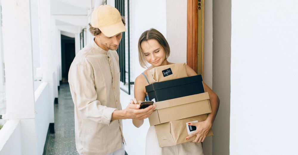 Gadget Boxes - A man and woman engaged in a home delivery package exchange, smiling.