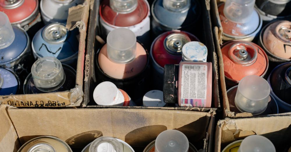 Artist Boxes - Close-up view of assorted spray paint cans neatly arranged in cardboard boxes.