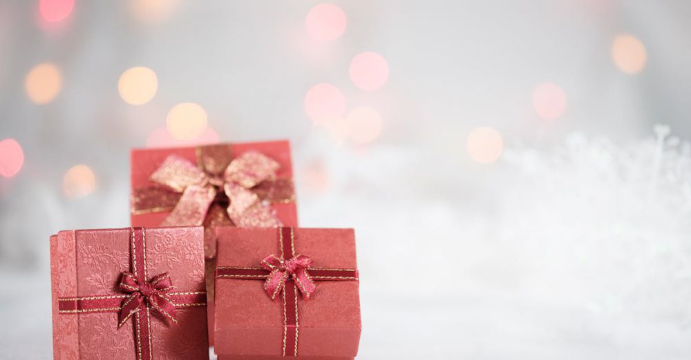 Gifts - Elegant red gift boxes with ribbons and bows, set against a festive bokeh backdrop.