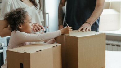 Personalized Boxes - A family labeling moving boxes in their new home, capturing a domestic moment.