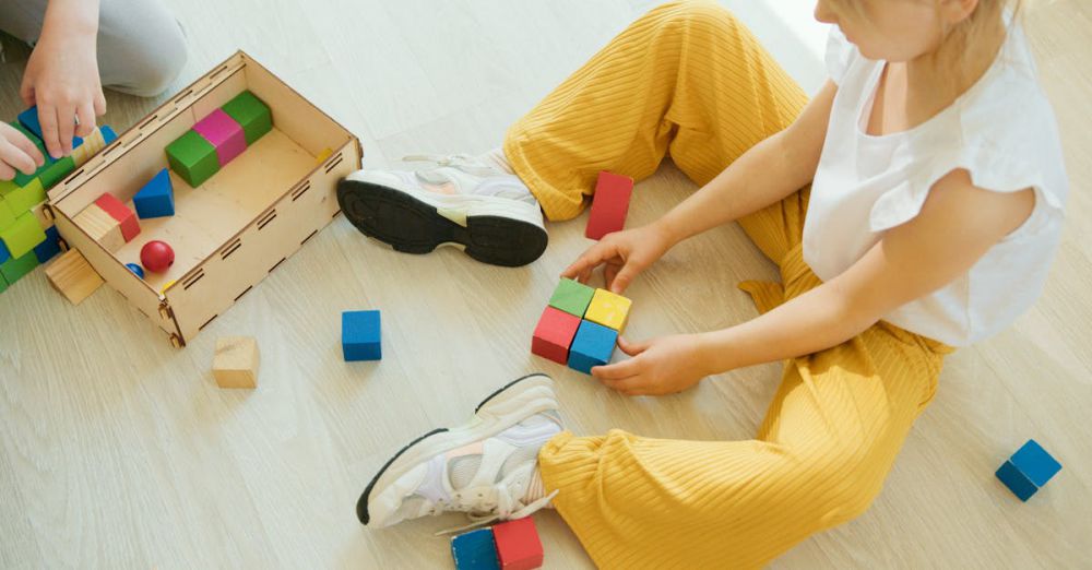 Learning Games - A young child playing creatively with colorful wooden blocks indoors, fostering learning and development.