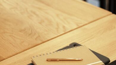 Learning Tablets - A close-up shot of notebooks and a pen on a wooden desk, perfect for education themes.