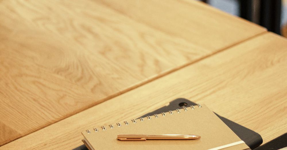 Learning Tablets - A close-up shot of notebooks and a pen on a wooden desk, perfect for education themes.