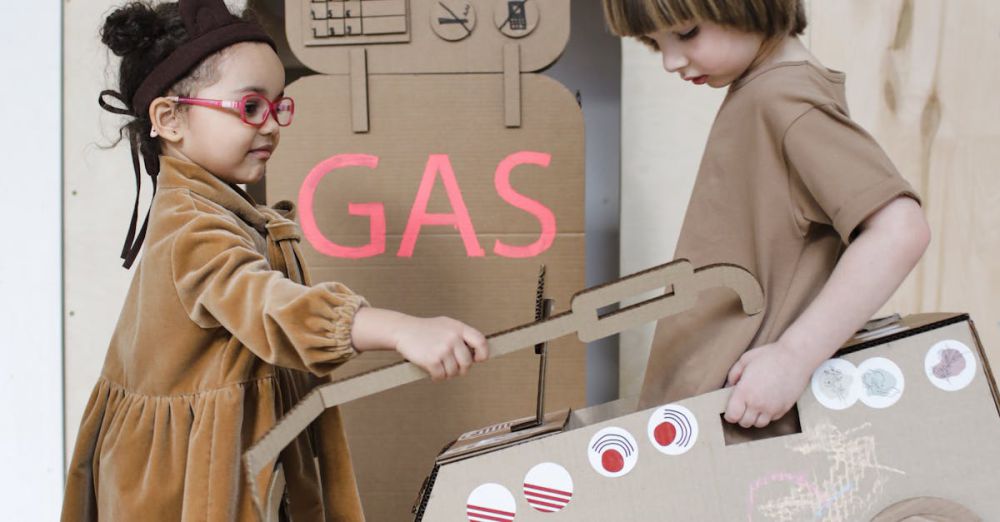 Role-Playing Toys - Adorable children role-playing with a cardboard gas station indoors, sparking creativity and imagination.