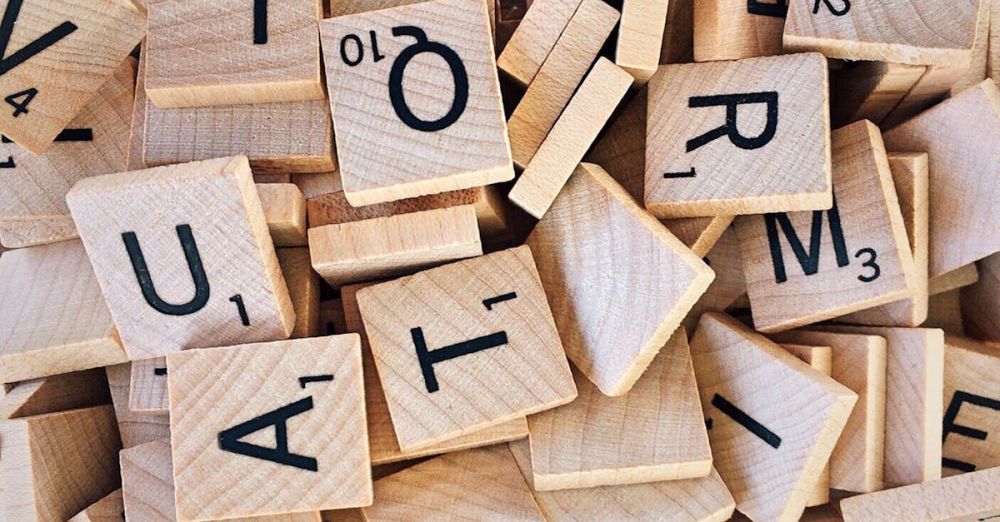 Language Tools - Close-up of wooden Scrabble tiles showcasing letters and numbers for word games.