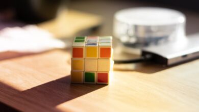 Math Games - A Rubik's Cube sits on a desk, bathed in sunlight, with blurred background elements.