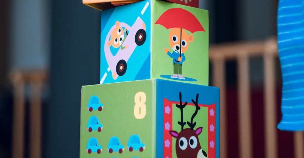 Development Games - A child playing indoors, stacking colorful wooden toy blocks with joyful illustrations.