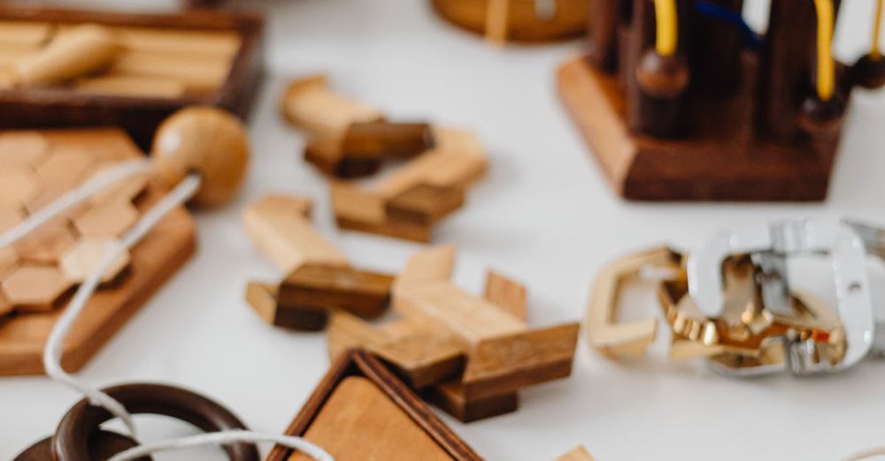 Problem-Solving Toys - A variety of wooden brain teasers and puzzles on a white tabletop.