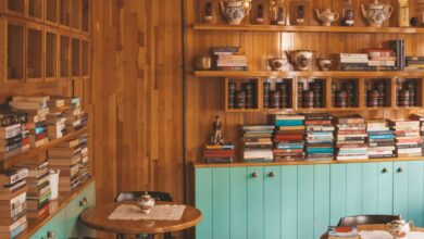 Coffee Tables - Warm and inviting coffee shop with books, wooden walls, and vintage decor.