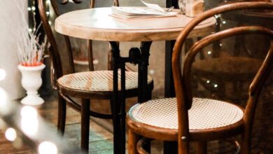 Dining Room Sets - Elegant café setting with classic wooden chairs and a round table, offering a warm atmosphere.