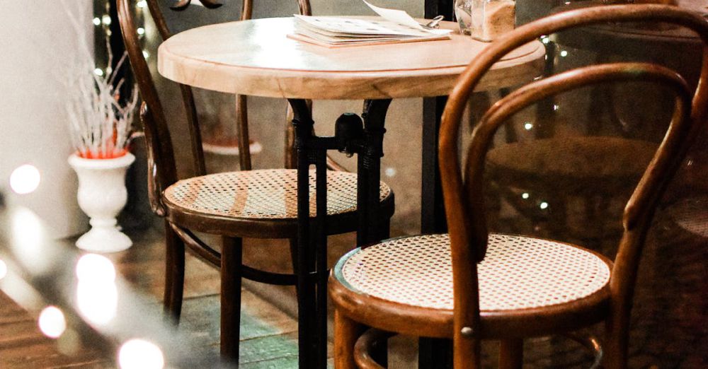 Dining Room Sets - Elegant café setting with classic wooden chairs and a round table, offering a warm atmosphere.