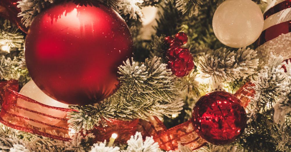 Ornaments - Close-up of festive Christmas tree decorated with red and white ornaments and snow-covered branches.